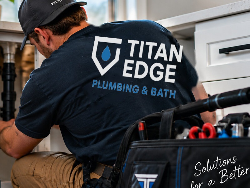 Titan Edge branded plumber working at a kitchen sink